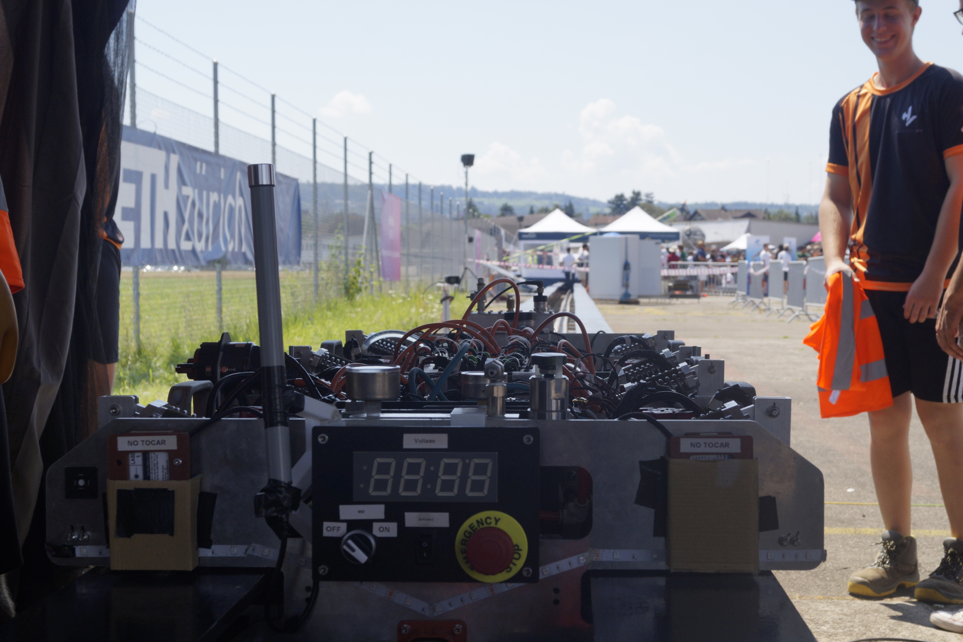 Hyperloop UPV vehicle resting on the competition track in partial shadow, poised for testing with MEAN WELL-supported power systems onboard.